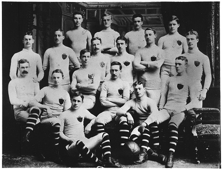 A black-and-white photograph of the McGill University rugby football team. They are wearing striped knee socks and white uniforms adorned with a crest.