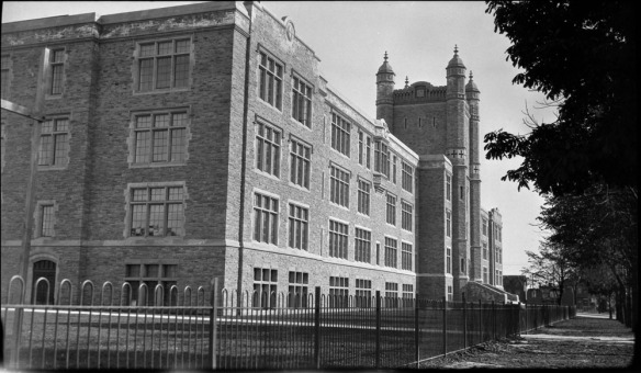A black-and-white photograph showing a large building taken from the side.