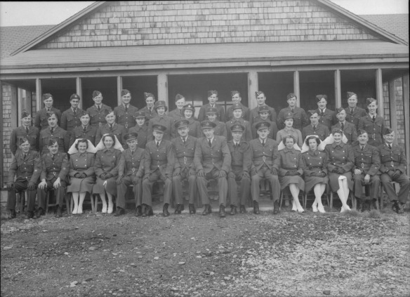 A formal group photo with 41 individuals, including 12 servicewomen, five of whom are wearing the distinctive white veil of a nursing sister. The group is organized in three rows; the front row is seated.